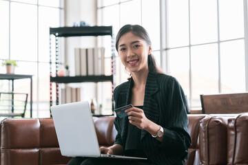 Asian business woman I'm using my credit card for online shopping. with personal laptop in the office rest room