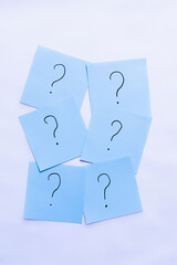 top view of blue cards with question marks on white background.