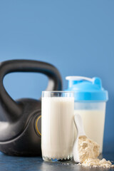 Protein sport shake and weight on blue background . Fitness food and drink. Diet. Copy space