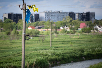 Ukrainian flag torn by the wind is tied to an electric pole against the backdrop of the city of Borodianka burned as a result of the Russian invasion of Ukraine. Borodianka, Ukraine