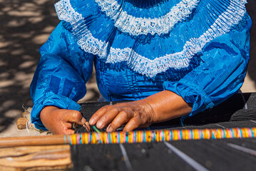 Hands of an artisan woman working on her loom	