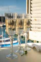 Three glasses of French champagne sparkling wine and view on colorful fisherman's boats in old harbour in Cassis, Provence, France