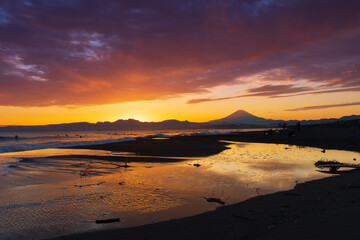 Fototapeta na wymiar 海岸から沈む夕日と富士山