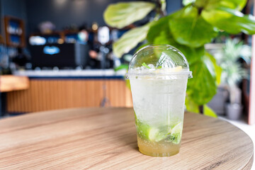 Refreshing drinks for summer, cold lemonade juice with sliced fresh lemons. Lemon juice cocktail on table with blurred counter bar background in cafe with copy space. Holiday and healthy drink concept
