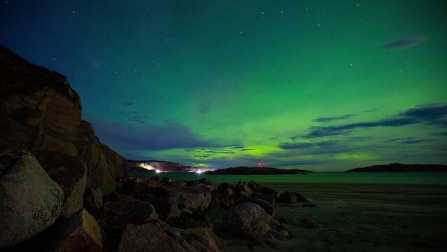 Nothern lights in Arctic. Timelapse of the sky with Aurora Borealis shining green. Town of Teriberka on Kola Peninsula in Russia