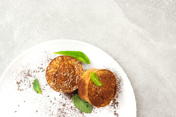 Apple and oatmeal cakes. Diet oat muffins with apples on a white plate on the gray background. Healthy food concept.