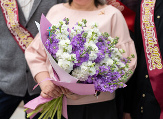 Bouquet at school teacher and students with graduation ribbon 2022