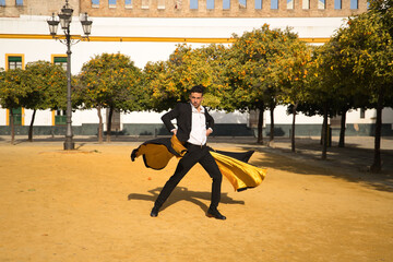 Young Spanish man in black shirt, jacket and pants, with dancing shoes, dancing flamenco with black...