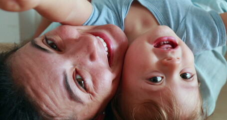 Playful mother and baby child together upside down