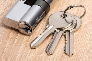 Door lock on wooden background. Key cylinder with keys