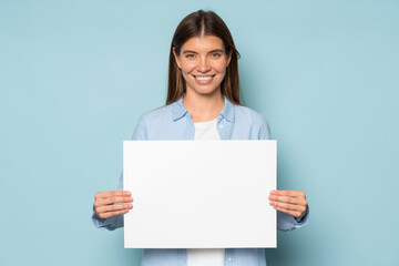 Young smiling hr manager offering vacancy showing empty blank board or mock up sheet of paper