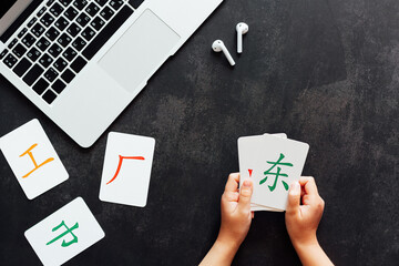 Flat lay mockup for online courses of Chinese language. Laptop and cards with basic printed...