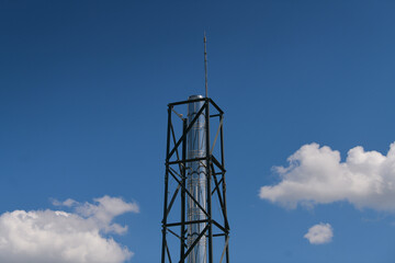 Air and heating ventilation chimney with scaffolding structure against blue sky.