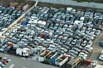 Fototapeta premium Aerial view of big parking lot of junkyard with rows of discarded broken cars. Recycling of old vehicles