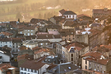 Fototapeta premium Aerial view of dense historic center of Thiers town in Puy-de-Dome department, Auvergne-Rhone-Alpes region in France. Rooftops of old buildings and narrow streets at sunset