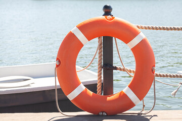 Pier with lifebuoy and boat. Boats for walking. Boats rental. Relax in the summer