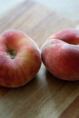 Plattpfirsiche auf einem Holzbrett