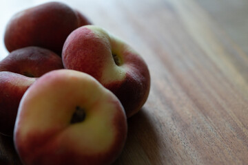 Plattpfirsiche auf einem Holzbrett