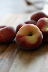 Plattpfirsiche auf einem Holzbrett