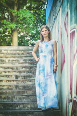 Young attractive woman in a long bright dress. Portrait of a young woman in a long dress outdoors. Copy of space.