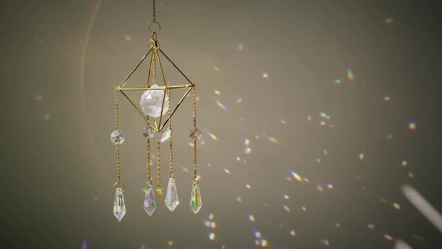 Close up crystal sun catcher in front of the wall at sunset time. Indoors. Good Feng Shui, energy flow concept. 4K UHD