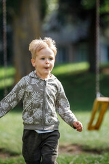 Adorable little boy running towards camera. Vertical photo.