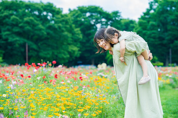 mother and her daughter strolling in the flower field
