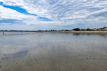 plage déserte avec reflets des nuages sur le sable