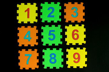 Colorful number puzzle isolated on black background. Number learning block for children education.

