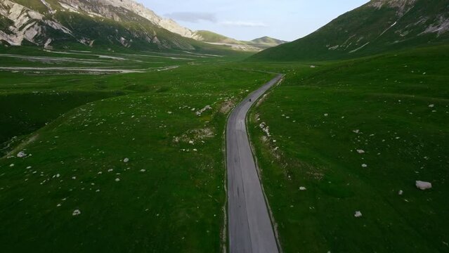 Motorcyclist rides asphalt mountain road. On a beautiful sunny day. In the Italian mountains of Gran Sasso in the Abruzzo region.