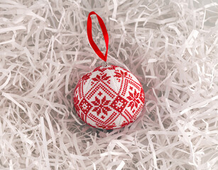 Cross stitched Christmas ornament on white shredded wrapping paper background. This Christmas ornament made by me.
