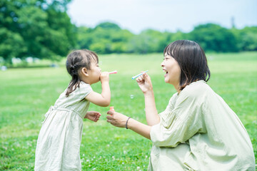 mother and her daughter playing with soap bubbles