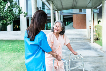 Asian elderly woman patient happy and smile, while doctor holding hands, encouraged and supported to her, Which holds a cane, do physical therapy to walk, concept to  health care and osteoarthritis.