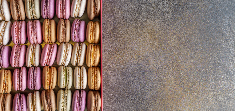 Cake french macaroons in box on concrete background, top view with copy space