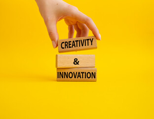 Creativity and innovation symbol. Concept word Creativity and innovation on wooden blocks. Beautiful yellow background. Businessman Hand. Business and Creativity and innovation concept. Copy space