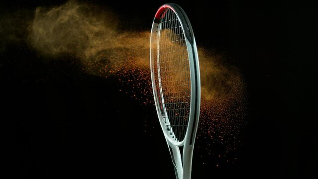 Super Slow Motion Detail Shot of Hitting Tenis Ball Containing Orange Powder by Racket at 1000 fps.