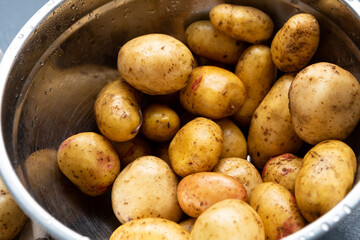 Close up of fresh wet potato ready for cooking in bowl