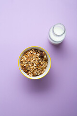 Grain granola in bowl for breakfast and milk in bottle food