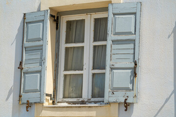 Fototapeta na wymiar Typical bluish wooden window on the island of Santorini during a sunny summer day