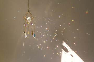 Suncatcher hanging in home during sunset. Many sun beams on the wall. Good Feng Shui, energy flow...