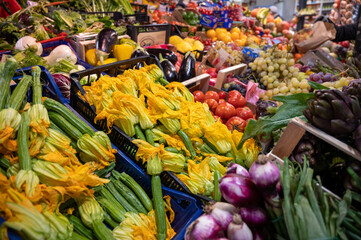 Yellow zucchini flowers and other fresh vegetables for sale on farmers market in Florence, Tuscany, Italy