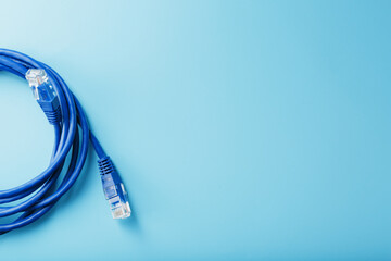 A coil of an Internet network cable for data transmission on a blue background