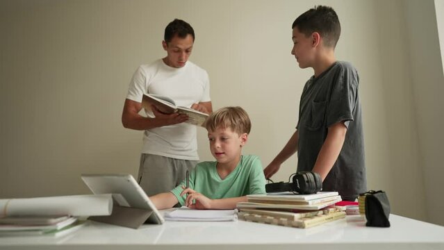 Parents doing homework with kids. Father and mother, and brother helping son do homework.