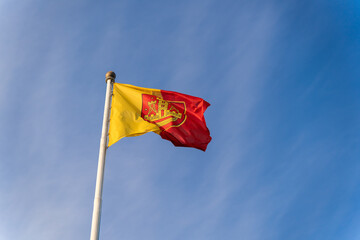 Flag and coat of arms of the city of Klaipeda on the background of the blue sky