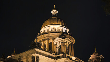 Obraz premium Beautiful architecture of Cathedral with dome and lighting in night. Action. Dome of Cathedral is illuminated with illumination at night. Illuminated Cathedral on background of night sky