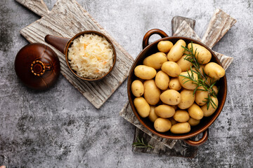 Raw small potatoes in a cast iron skillet on a beton background. - 509457518