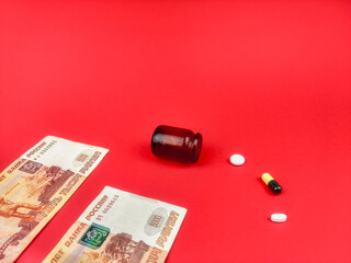 Tablets and money. Red background.