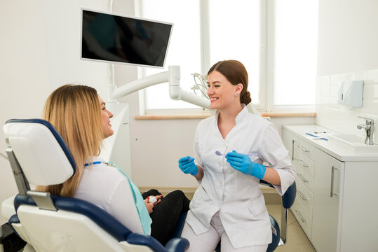 a female dentist explains to a patient, gesticulating with her hands.