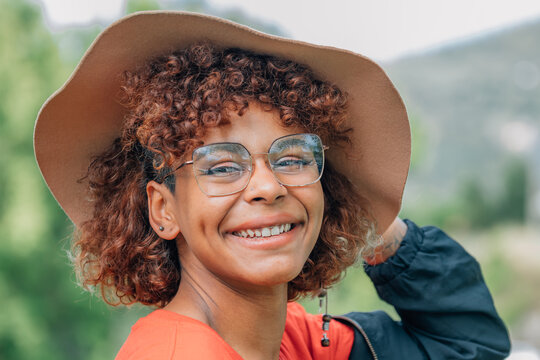 black girl with hat and glasses outdoors