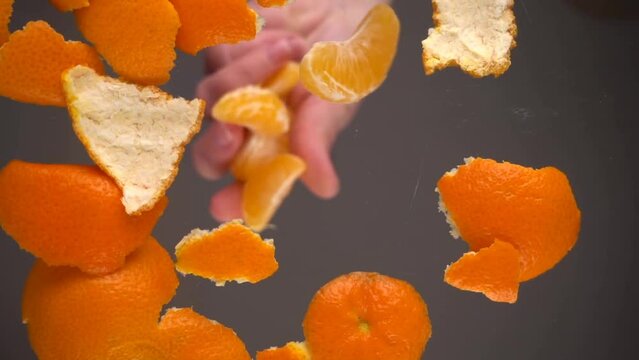 Falling mandarin slices on a background of tangerine